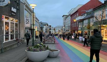 Colorful pedestrian street in a city with people walking, surrounded by buildings.