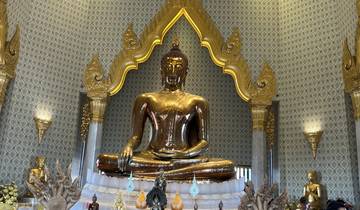 Golden Buddha statue in front of a decorated backdrop.