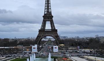 The Eiffel Tower seen through trees during sunset.