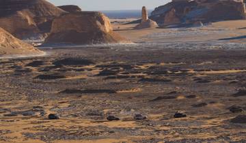 Dramatic desert landscape with vehicles on a journey.