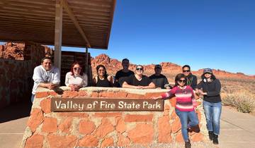 Group posing at Valley of Fire State Park with red rock formations.