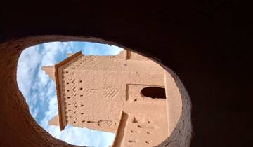 View of a desert structure through a circular hole.