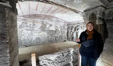 A woman explaining ancient Egyptian carvings.