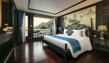 A comfortable bedroom interior in a luxury setting with a view of mountains and water.