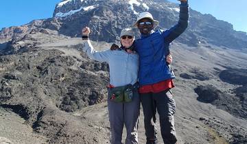 Two hikers posing in front of a mountain.
