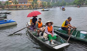 People in boats wearing life vests and hats on a river.