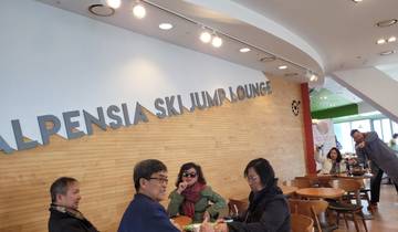 Group of people seated inside a ski jump lounge.