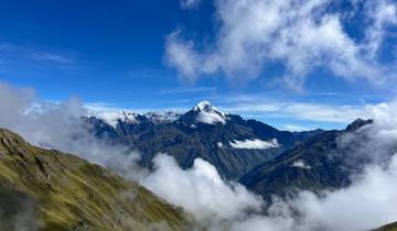 Snow-capped mountain with clouds surrounding the peak.