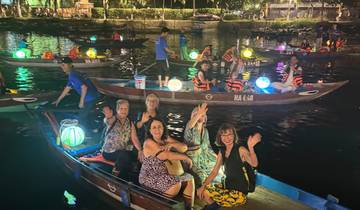 Nighttime boat ride with colorful lanterns lighting up the water.