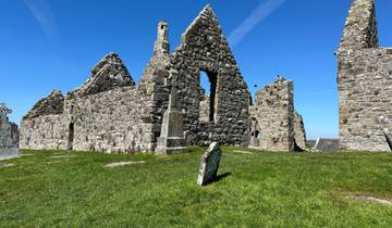 Ruins of an ancient stone building under a blue sky.