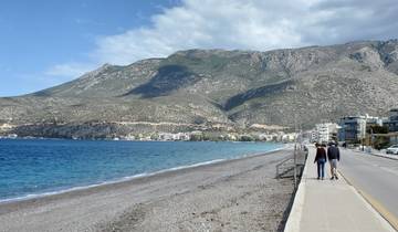 A view of a coastal road with mountains in the distance.