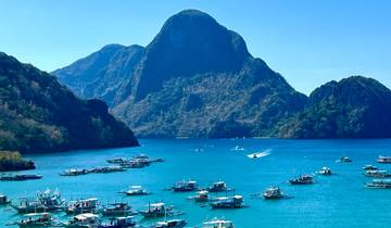 Seascape with traditional boats and rocky islands.
