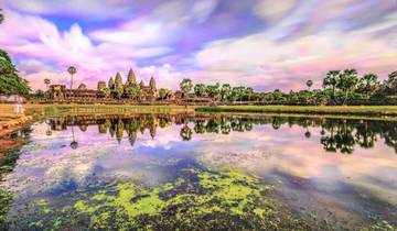 Reflection of Angkor Wat in the water with a vibrant sky.