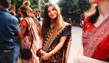 Smiling woman in traditional attire among a group of people.