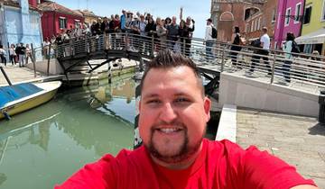 Selfie with a canal and bridge in the background.