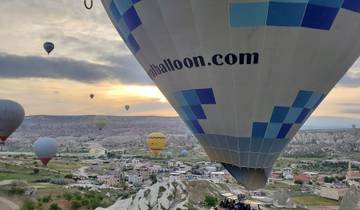 Hot air balloons over a rocky landscape at sunrise.