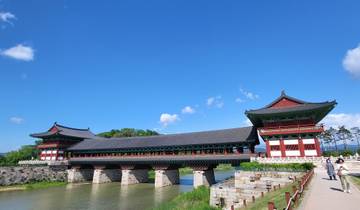Traditional Korean palace building with a bridge over water.