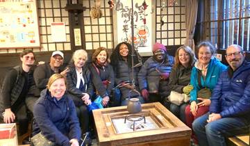 Group of people seated inside a traditional Japanese house with smiles.