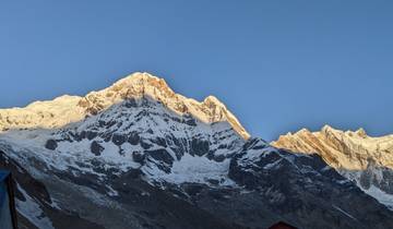 Snow-covered mountain peaks under a clear blue sky.