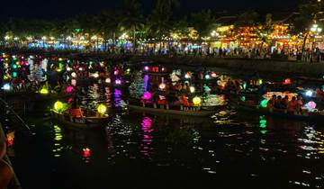 Lantern-lit boats on a river during a festival at night.