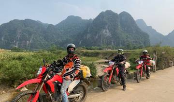 Motorcyclists on a scenic road with rocky hills.