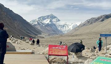 People hiking towards the base of Mount Everest with snowy scenery.