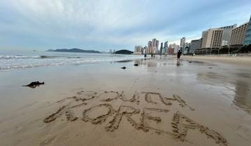 Beach with sand writing and skyline in the background.