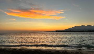 Sunset over the ocean with vibrant clouds.