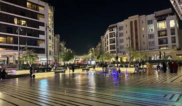 Vibrant city street at night with people and lights.