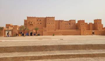 Large, brown-walled historic building with clear skies.