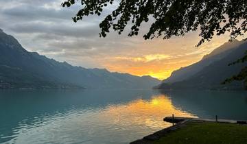 Sunset view of a lake surrounded by mountains.