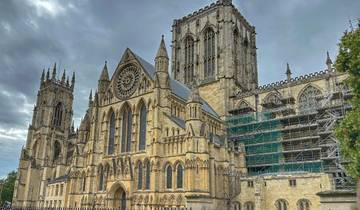 Large Gothic cathedral with intricate architecture under cloudy sky.