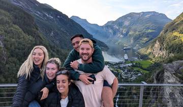 Group of friends posing with mountain and water views.