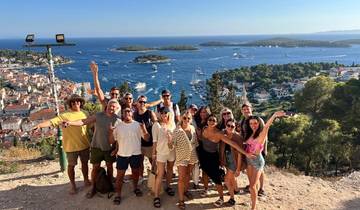 Group of people posing with a view of the coastline.