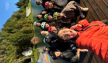 A group of cyclists posing near a lake.
