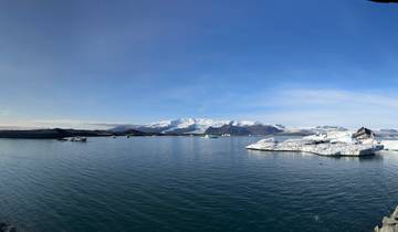 Icebergs floating in a calm body of water.