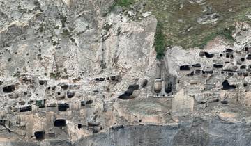 Rocky cliff with numerous cave dwellings.
