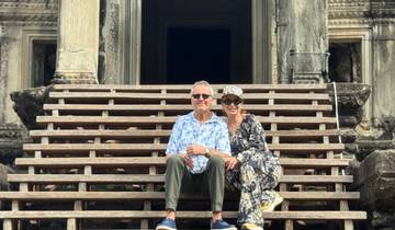 Two people sitting on steps in front of an ancient temple.