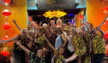 Large group photo in front of a lantern-covered entrance.
