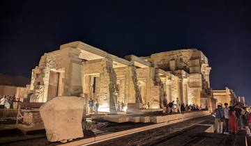 Ruins of an ancient Egyptian temple illuminated at night.
