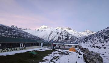 Mountainous snowy landscape with a lodge and tents.