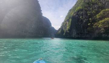 Clear blue water between tall cliffs under a bright sky.