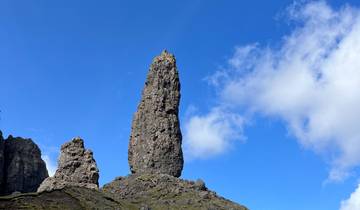 Tall rock formation set against a bright blue sky.