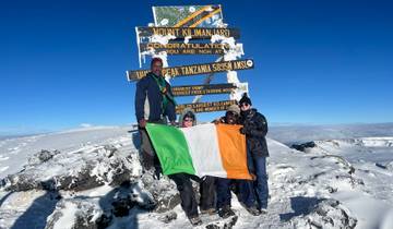 Group at mountain peak with an Irish flag.