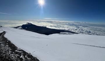 Snow-covered landscape with a mountain view under a bright sun.