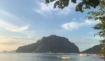 Calm bay surrounded by mountains with boats in the water.