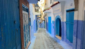 Narrow, colorful and ornate alleyway with blue doors.