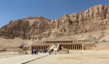 Tourists visiting a grand stone temple with steep stairs.