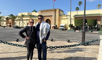 Two people posing in front of a historic building.