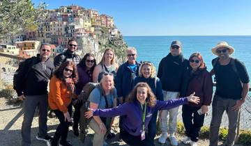 Group of people with a colorful cliffside town in the background, likely Cinque Terre.